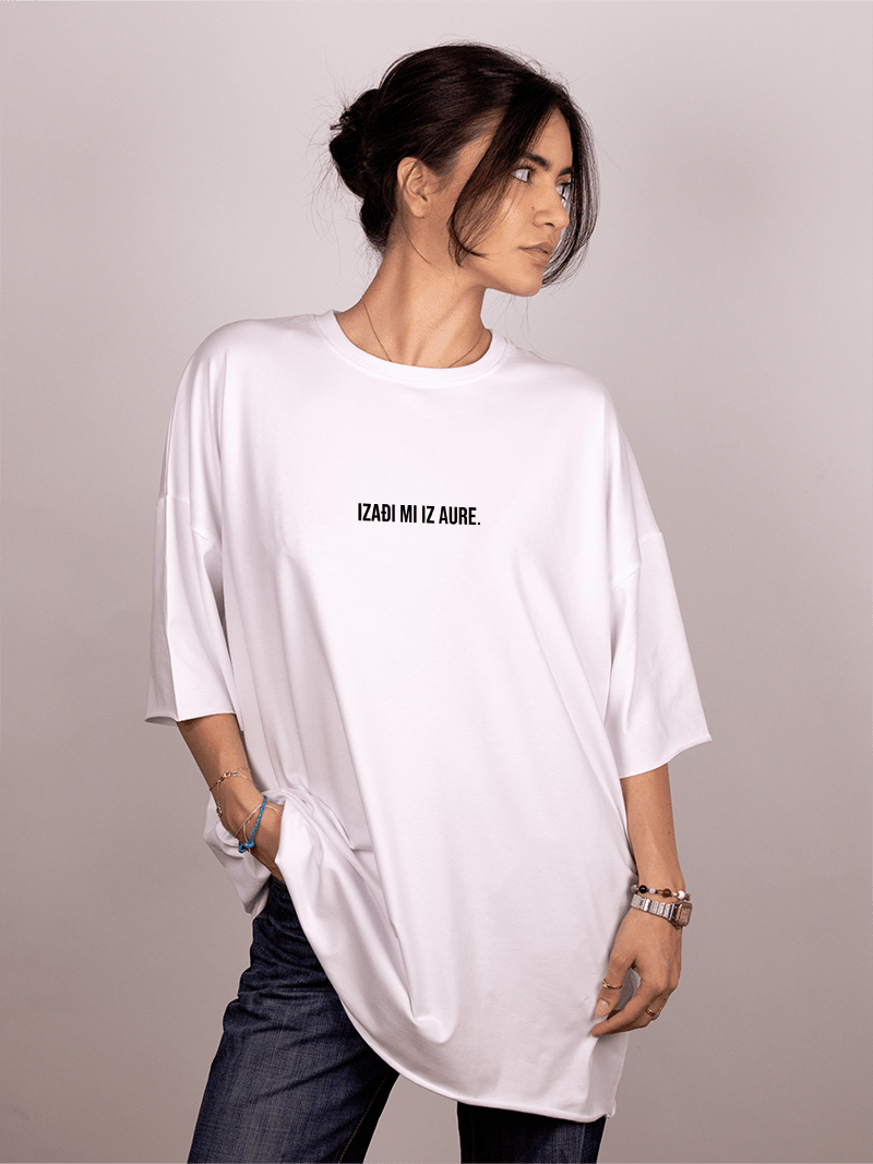 Person wearing a white oversized "Ivica i Majica" t-shirt with text on a plain background