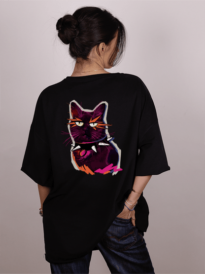 Girl wearing a black "Ivica i Majicat-shirt with a colorful cat graphic on the back against a plain background 