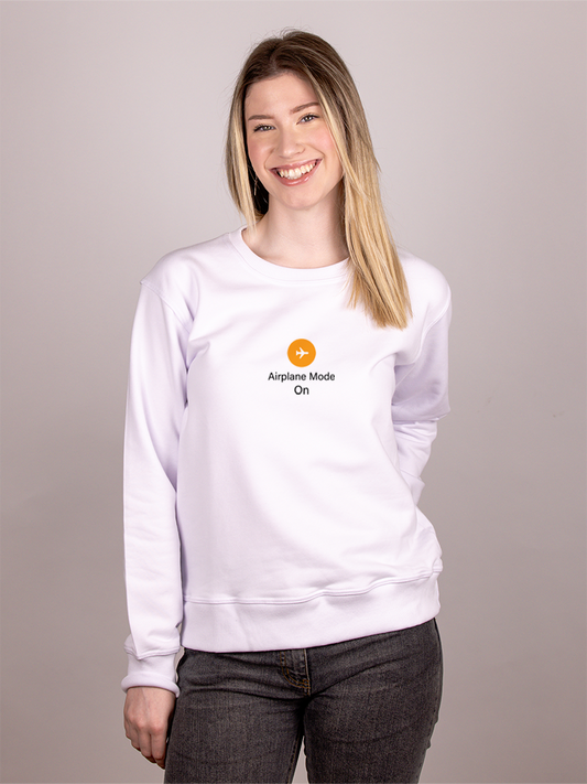 Woman wearing a white sweatshirt with an airplane mode logo on a plain background